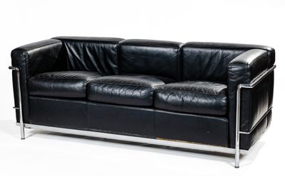 black leather sofa with chrome legs and arm rests against a white background