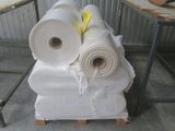 several rolls of paper are stacked on top of each other in a warehouse