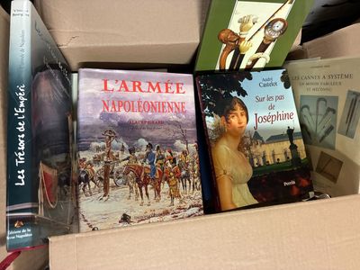 de nombreux livres dans une boîte, posée sur une table