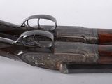 pair of old guns on a white surface with a white background