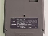 an old nintendo game is sitting on a white surface