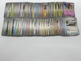 a pile of pokemon trading cards sitting on top of a table