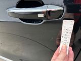 a person holding a ticket in front of a car door