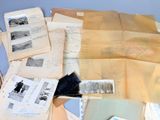 a pile of old papers and old photos on a table