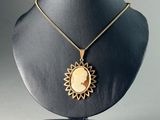 a black mannequin with a gold sun pendant on it