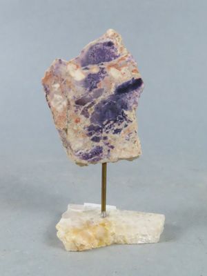 deux morceaux d'améthorate posés sur un socle, sur une surface grise
