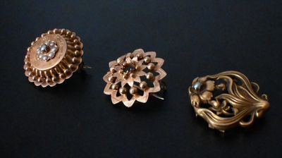 trois paires de boucles d'oreilles couleur or et une broche