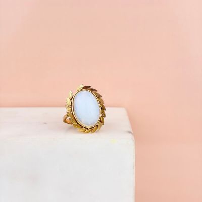 a white stone ring sitting on top of a marble block