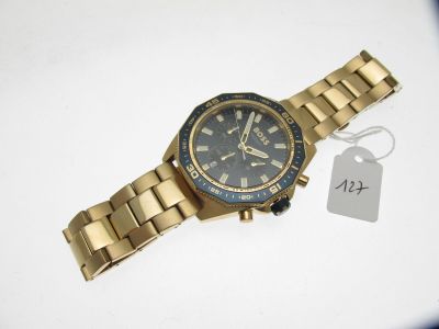 une photo d'une montre-bracelet en or sur laquelle est accrochée une étiquette