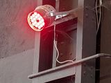 a red light that is on the side of a building