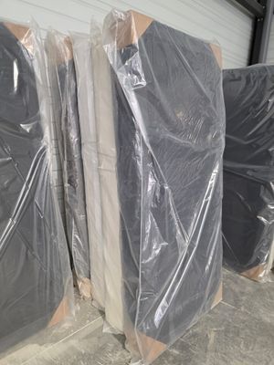 de nombreux matelas emballés dans du plastique dans un entrepôt