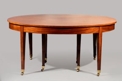 une table de salle à manger ovale avec quatre pieds et un plateau en bois