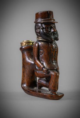 une figurine en bois représentant un homme avec un chapeau et une pipe
