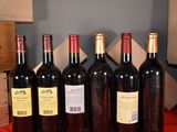 several bottles of red wine are lined up on a table