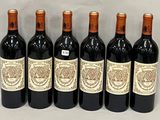 six bottles of wine are lined up in a row on a table