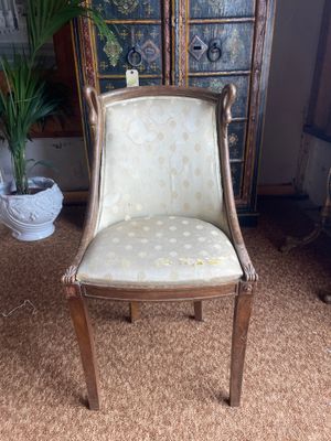 an old chair is sitting in a room with a potted plant in the corner