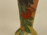 a vase with a painting on it sitting on a table