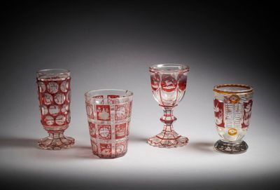 Plusieurs verres à pied sont alignés sur une surface blanche