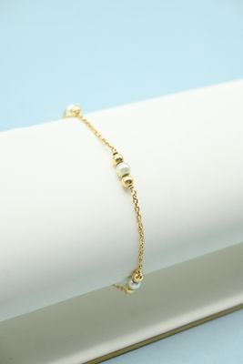 a close up of a gold bracelet on a white napkin