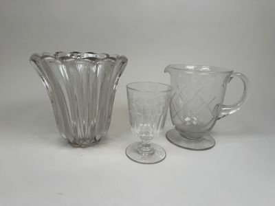 trois verres posés sur une table, à côté d'un pichet et d'un verre à pied