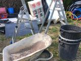 a wheelbarrow, a bucket, a ladder, a bucket, and a bucket of dirt in a yard
