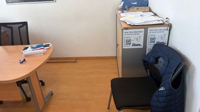 un bureau avec une chaise et un réfrigérateur dans un coin