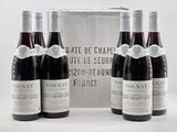 trois bouteilles de vin rouge sont posées devant un coffret en argent