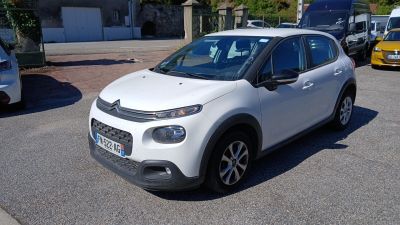 une petite voiture blanche garée dans un parking