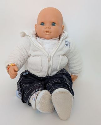 a baby doll that is sitting on a white surface