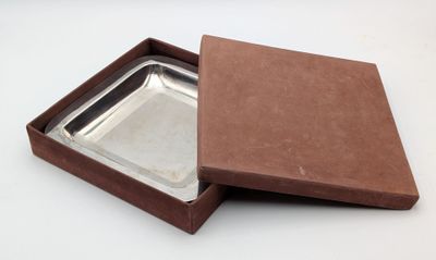 an open brown box with a silver tray inside of it