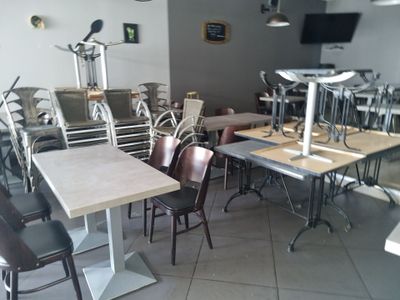 de nombreuses tables et chaises dans une pièce équipée d'une télévision