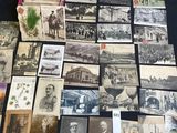 an old photo of a table full of old photographs and postcards