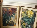 two paintings on the floor next to a vase and a vase