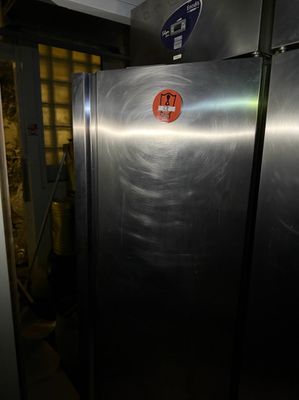 un grand réfrigérateur en acier inoxydable dans une pièce sombre