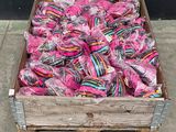 a wooden crate filled with lots of pink and blue lollipops