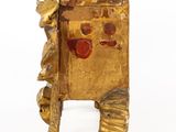 a small gold box with a face on it