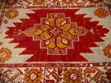 an image of a red and yellow rug with a cross design on it