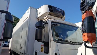 a white truck that is parked next to another truck