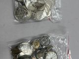 deux sacs d'argent et des pièces d'argent posés sur une table
