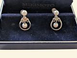 two pairs of earrings in a black box on a white background