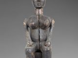 an image of a statue of a woman sitting on a stool