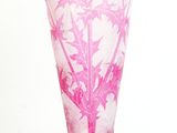 a pink vase with a tree on it on a glass stand