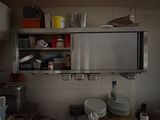 a microwave that is on top of a shelf in a kitchen