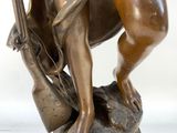 bronze statue of a man with a bow and arrow on a rock