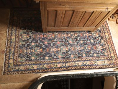 un tapis posé à même le sol, à côté d'une armoire en bois