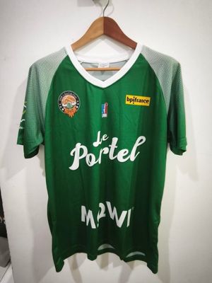 un maillot de foot vert suspendu à un cintre dans une pièce