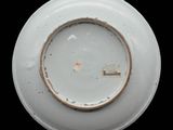 a white plate with a brown rim on a black background
