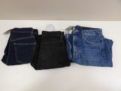 three pairs of jeans are lined up on a table
