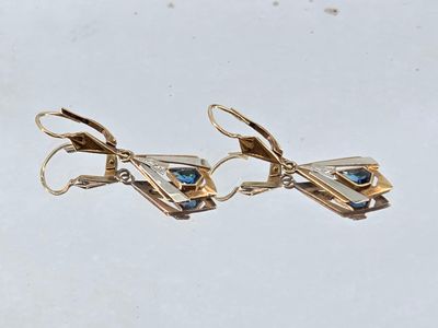 two pairs of gold earrings with blue stones on them