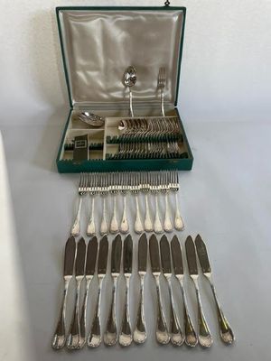 une boîte contenant des couverts, posée sur une table à côté d'un couteau et d'une fourchette